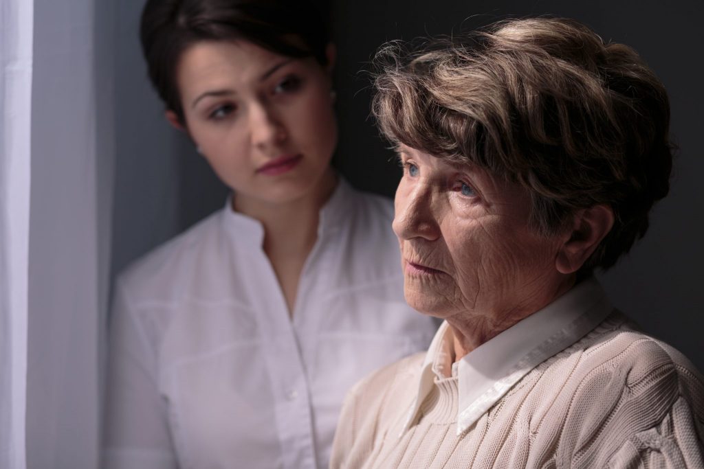 daughter looking at elderly mother concerned about Alzheimer's