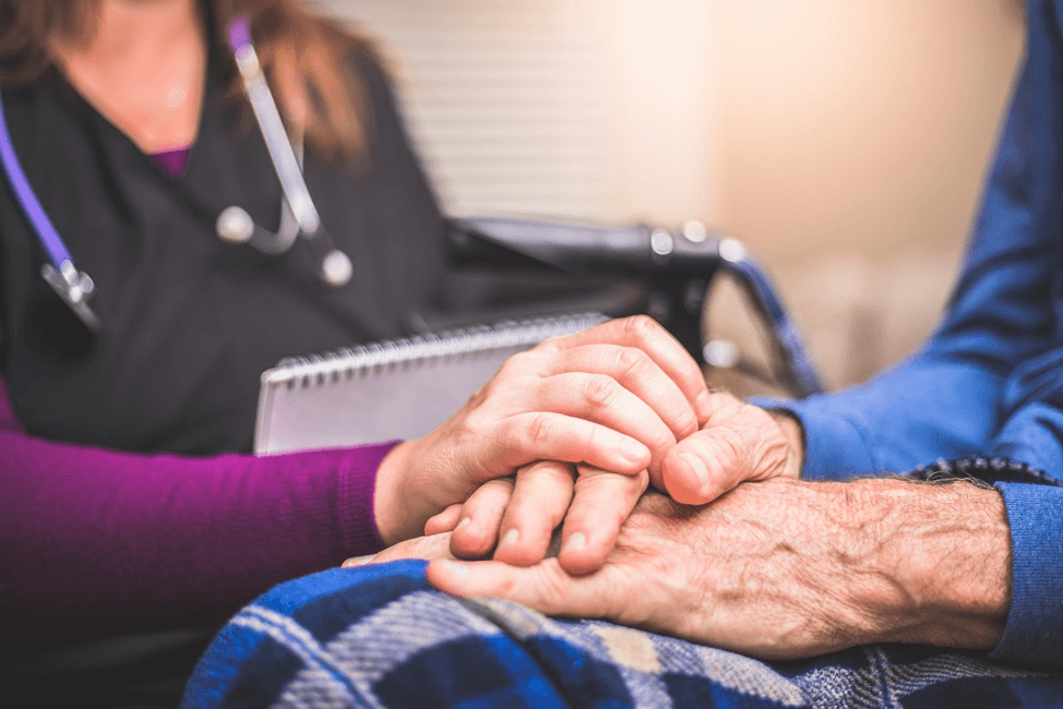 Nurse holding the hand of an older person