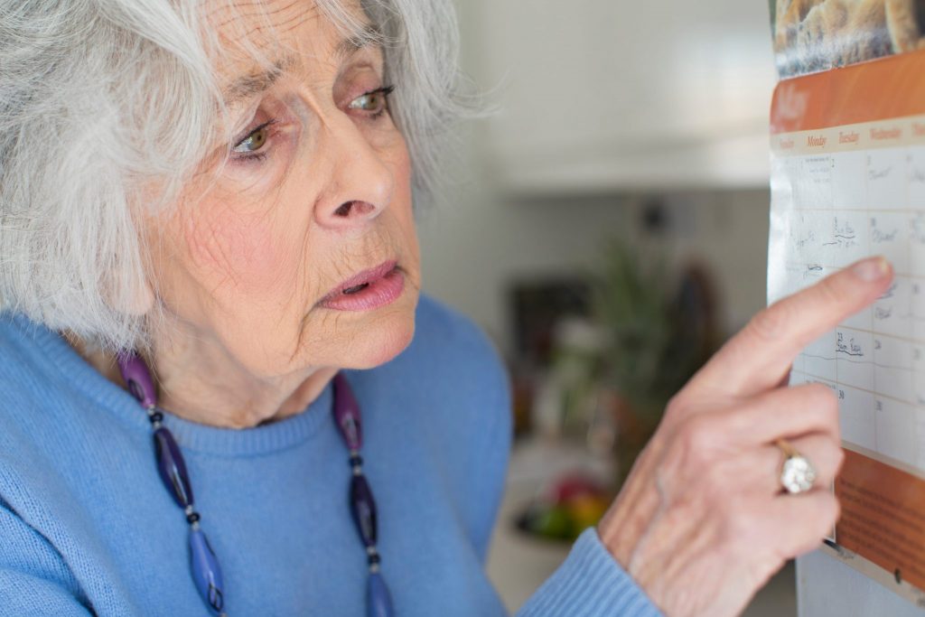 elderly woman pointing at date on calendar
