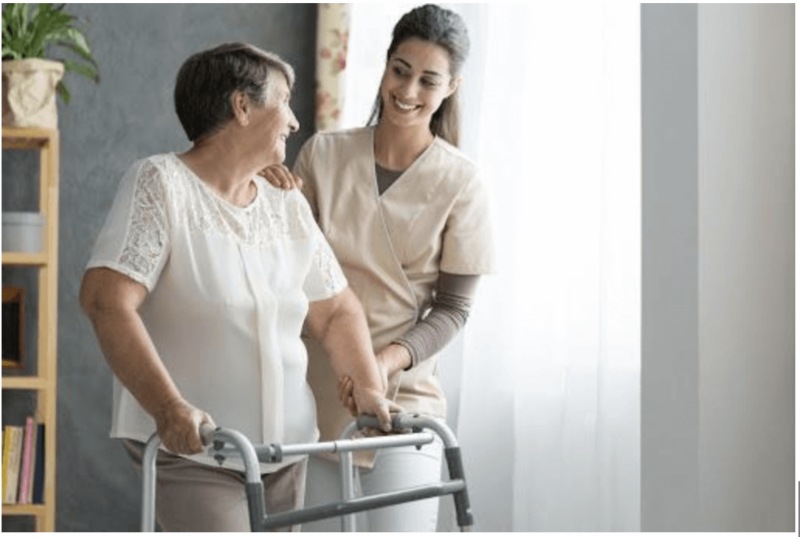 SmithLife Homecare caretaker helping older woman walk