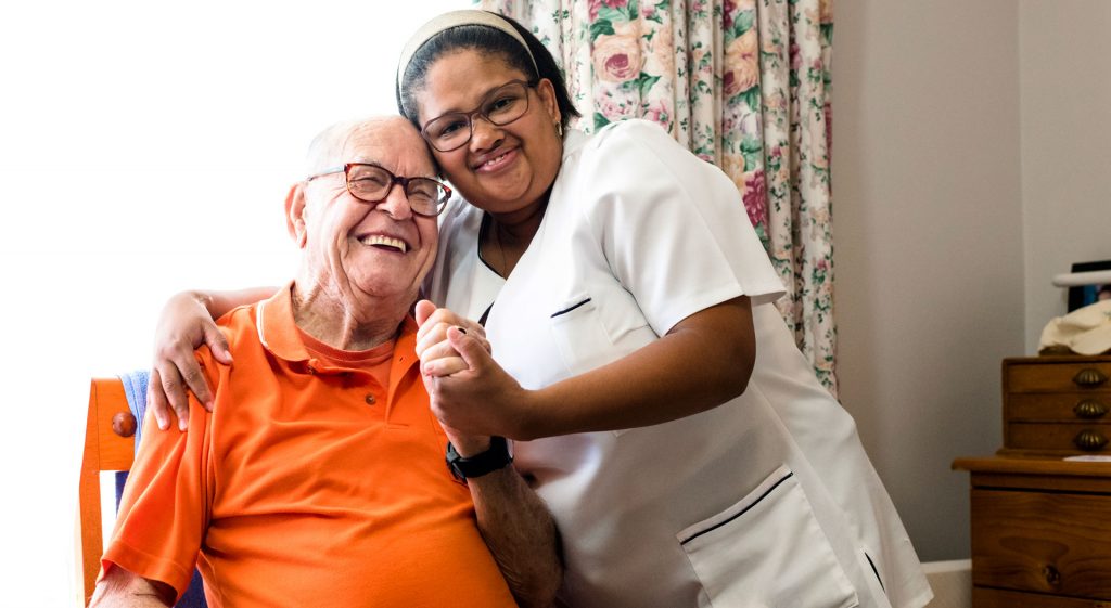 The homecare staff giving hug to the old man