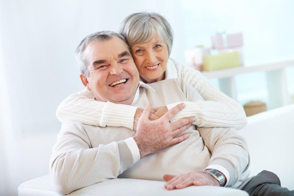 elderly at home holding each other on the couch