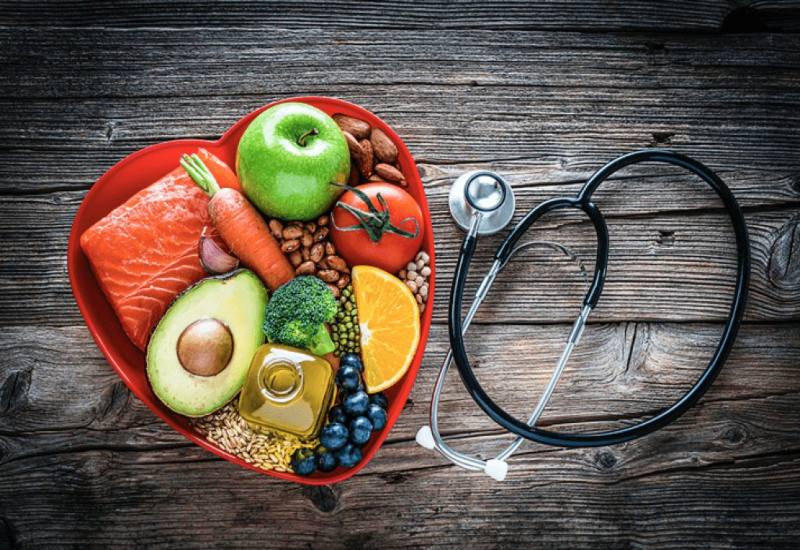 The Table with bowl of health nutrients fruits and vegetables and stethoscope