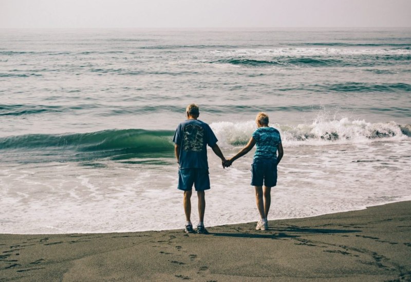 Older couple holding hands at beach