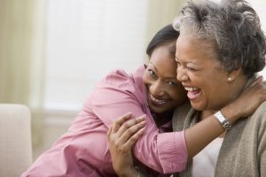 Caregiver holding senior at home while providing care