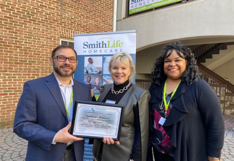 Three Certified Dementia Practitioners from SmithLife Homecare holding a plaque. in Chevy Chase, Maryland