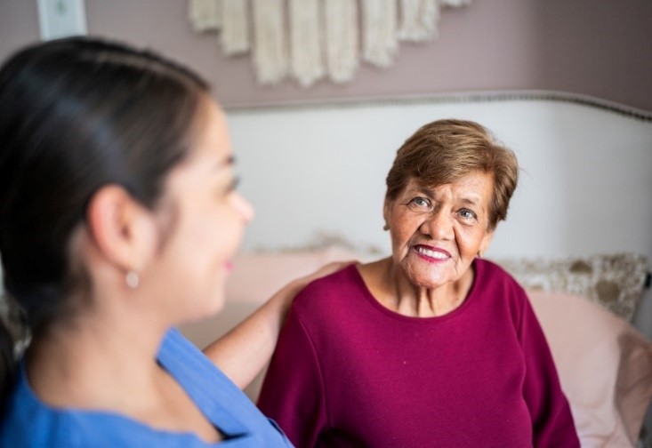 A home healthcare worker comforts a woman getting 24/7 care in her Rockville, MD home.