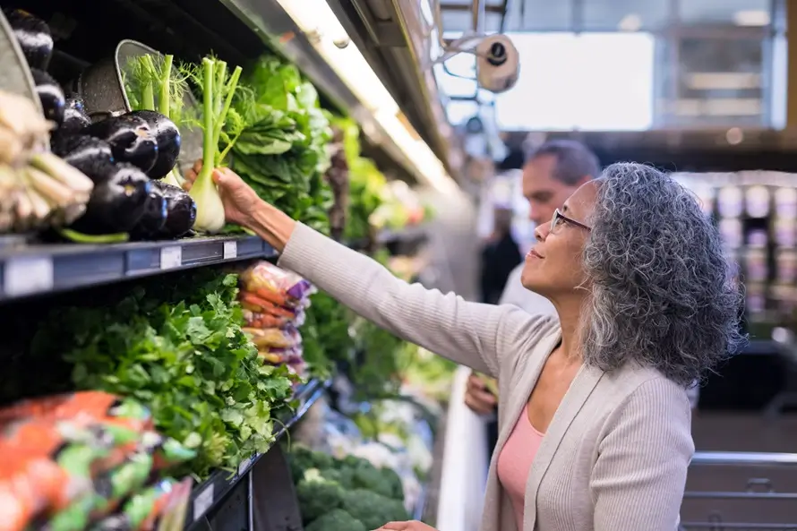 Older adult woman picking out fresh produce at a Maryland market