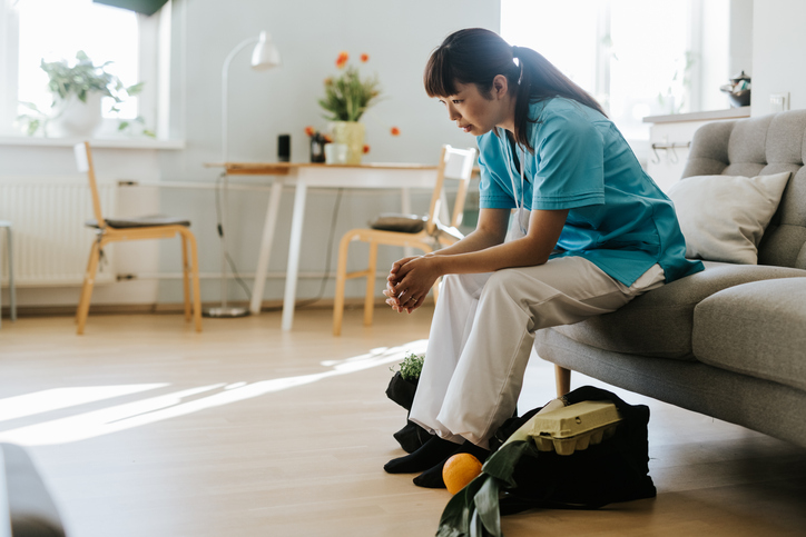 A nurse experiencing burnout, tired and stressed in a hospital setting
