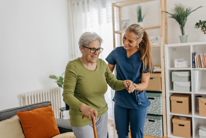 Caregiver Assisting a Senior with Walking Support and Companion Care Services at Home