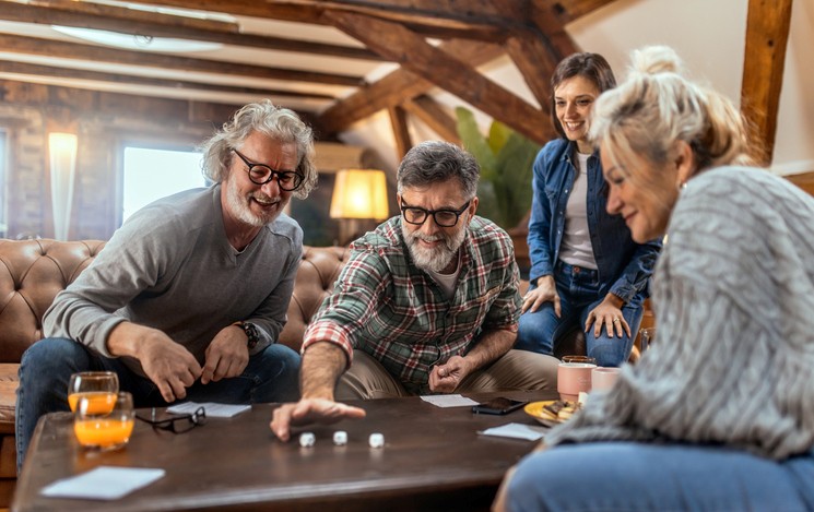 A group of adults playing a board game and laughing in Maryland & Washington, DC