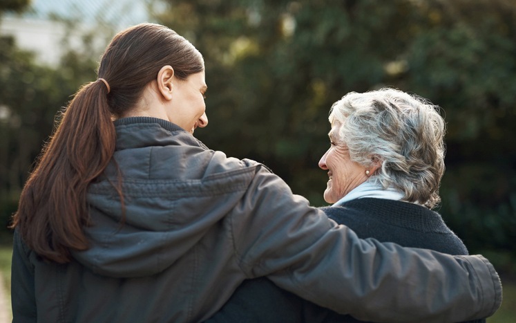 A young woman hugging an elderly woman outdoors in Maryland & Washington, DC
